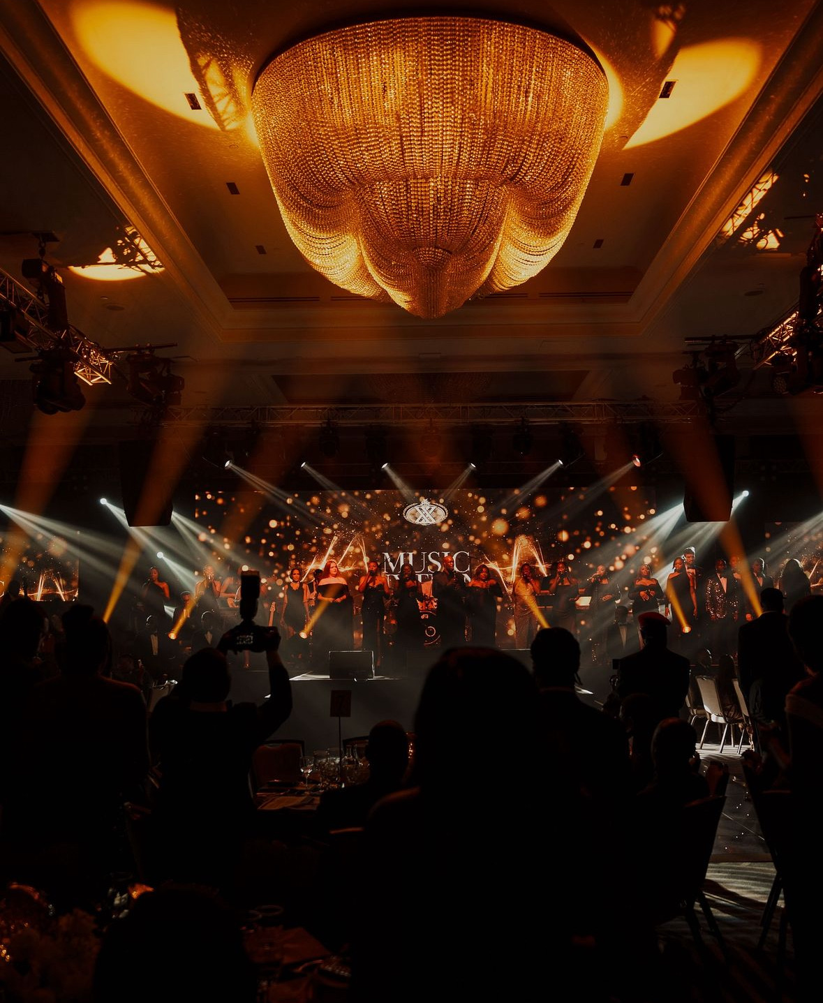 Music Nxtion choir performing under cinematic gold lights